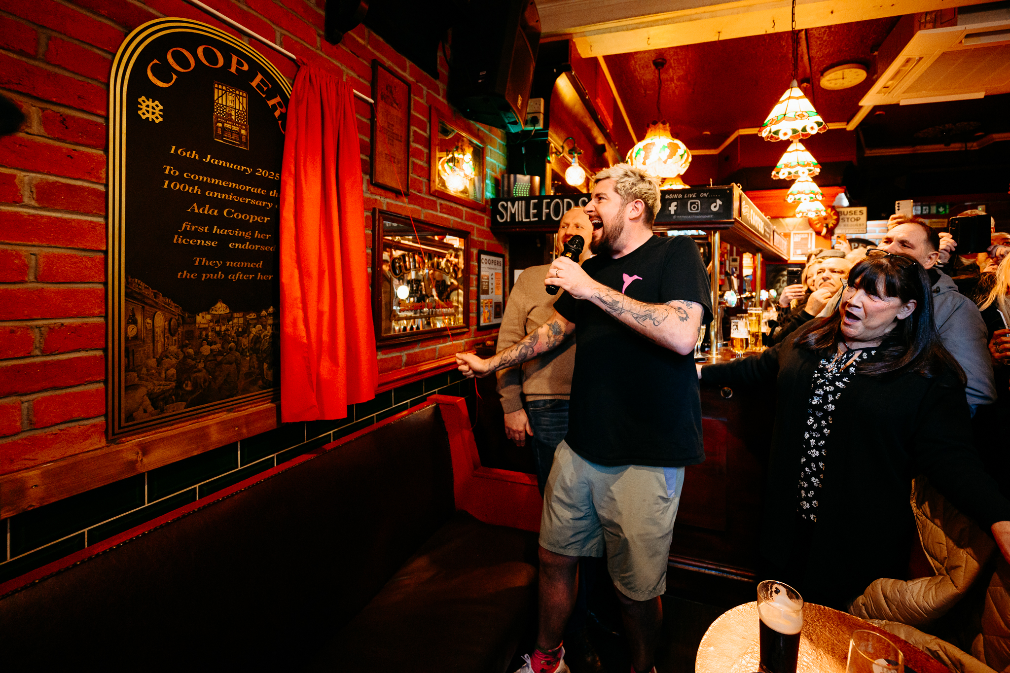 Man holding microphone unveiling plaque